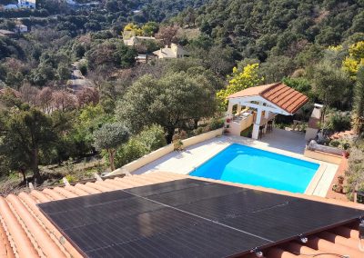 Toit recouvert d'une installation photovoltaïque donnant sur une piscine